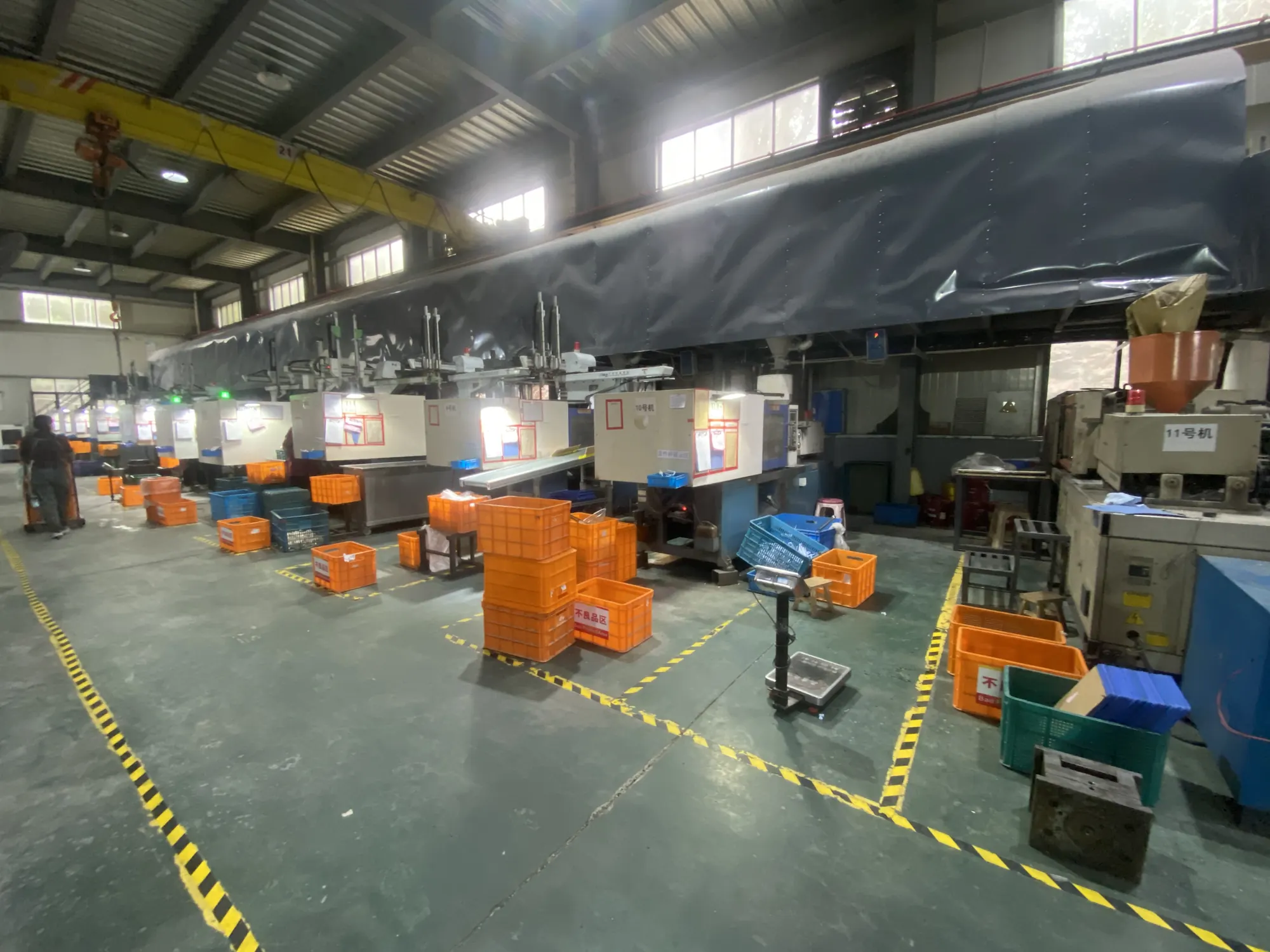 Cenfan production hall in Yuyao, Ningbo — injection molding machines and work-in-progress crates